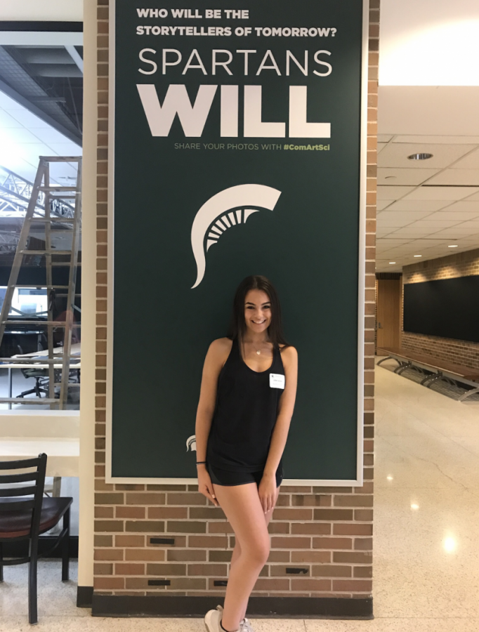 Lilly Swanson, senior, stands in Michigan State Universitys hallway with a smile. 