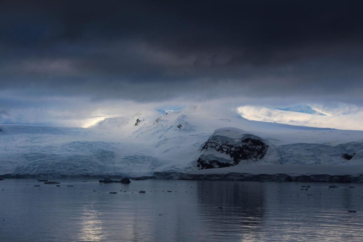 A break in the clouds allows two beams of light to shine upon the sides of a mountain along the Gerlache Strait in Antarctica.   