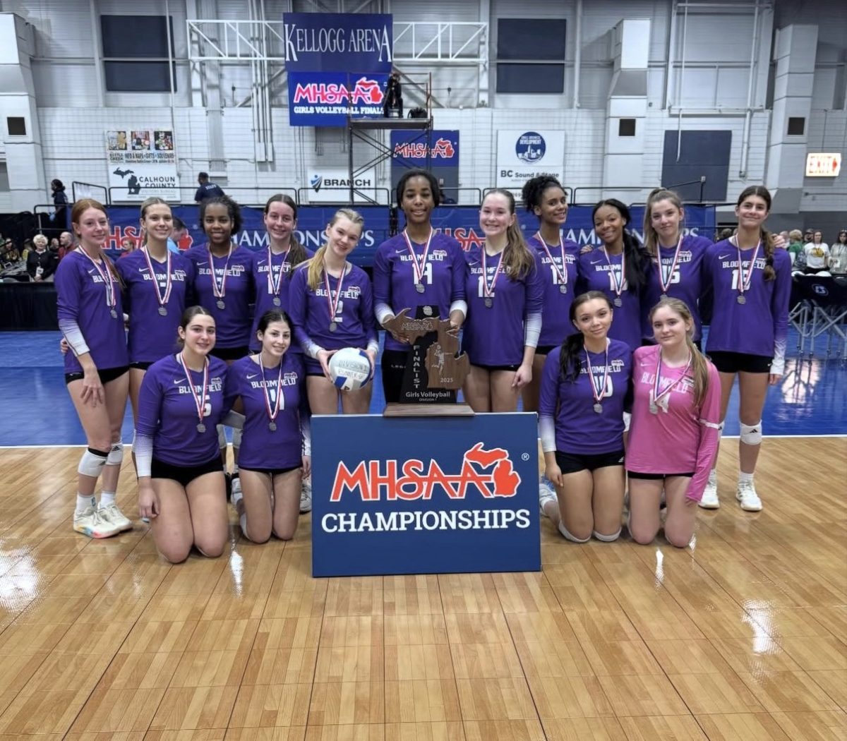The Varsity Volleyball team with the 2nd place trophy after competing in the division 1 state finals game at Kellogg Arena.